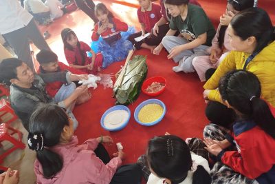 Hình ảnh phụ huynh và học sinh lớp 4D tham gia trải nghiệm gói bánh chưng